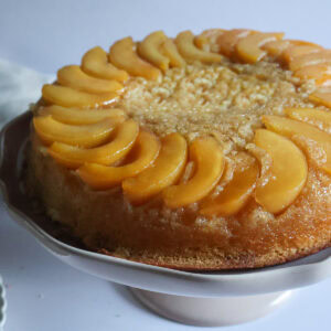Peach upside down cake on cake platter.