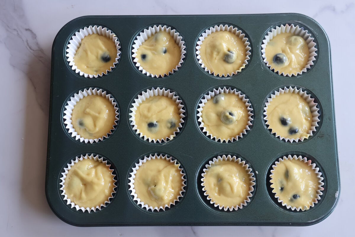 Blueberry muffin mix in muffin pan.