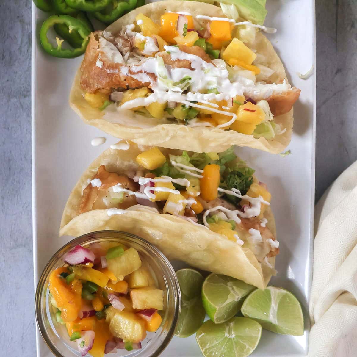 Fish tacos with pineapple mango salsa and sour cream drizzle.