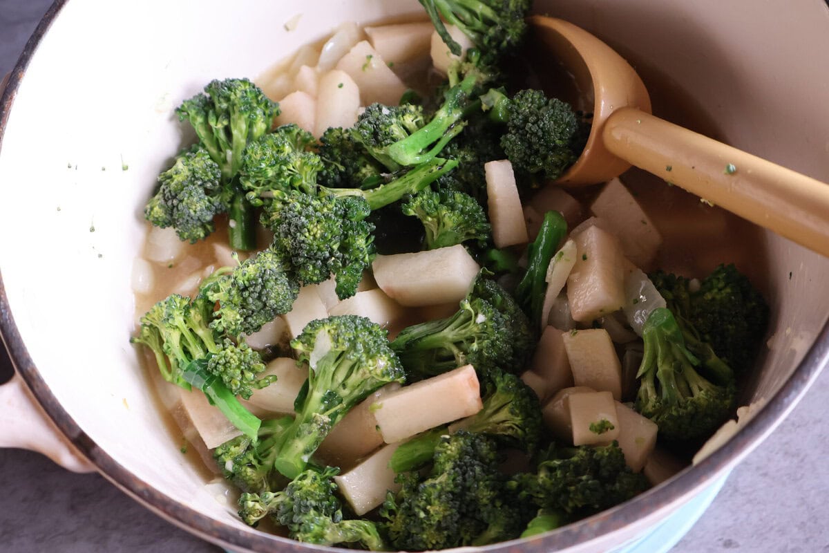 Broccolini and potato added to a pot.