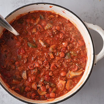 pizza chili in a white pot with a ladle.