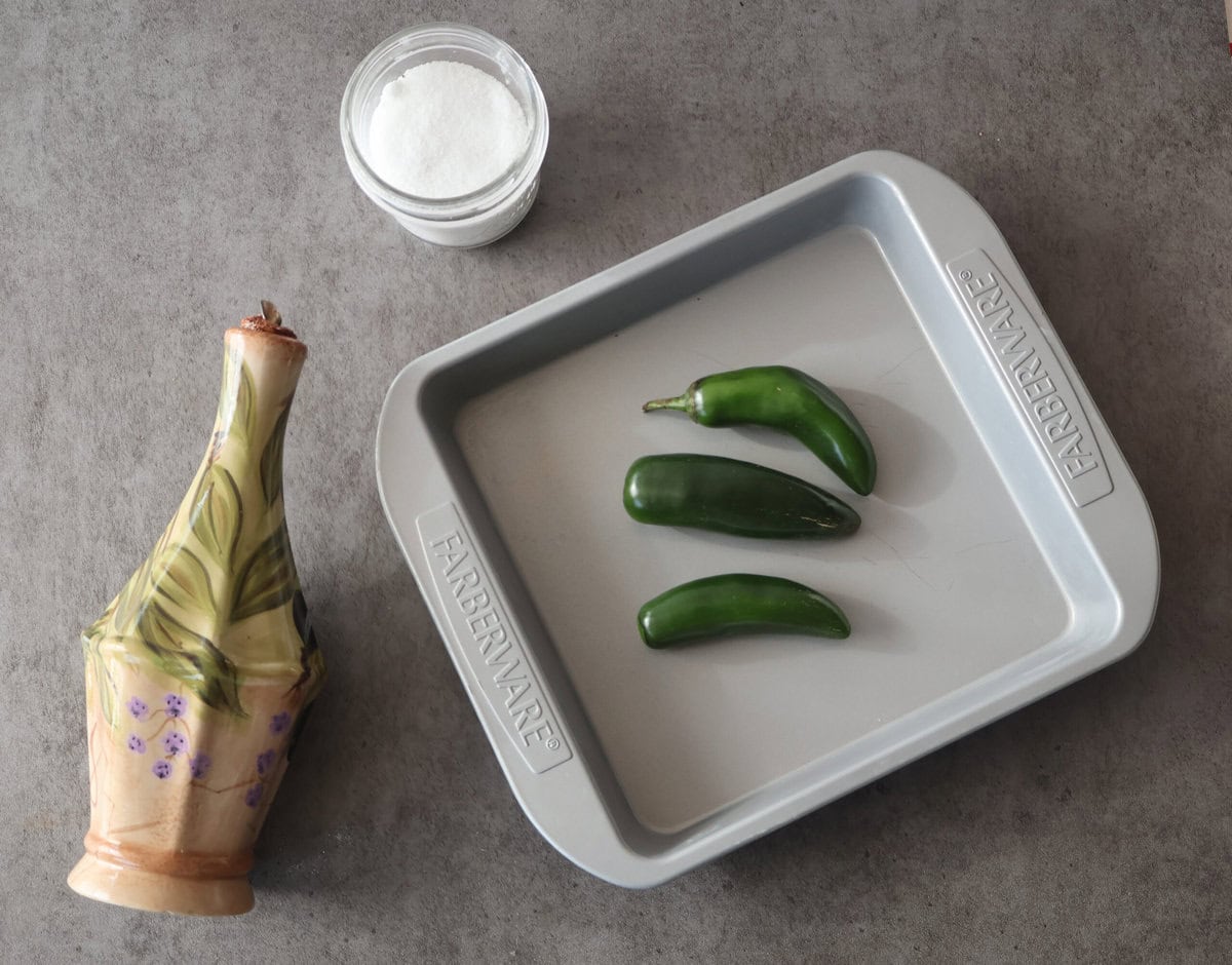 Jalapenos on baking sheet before roasting.