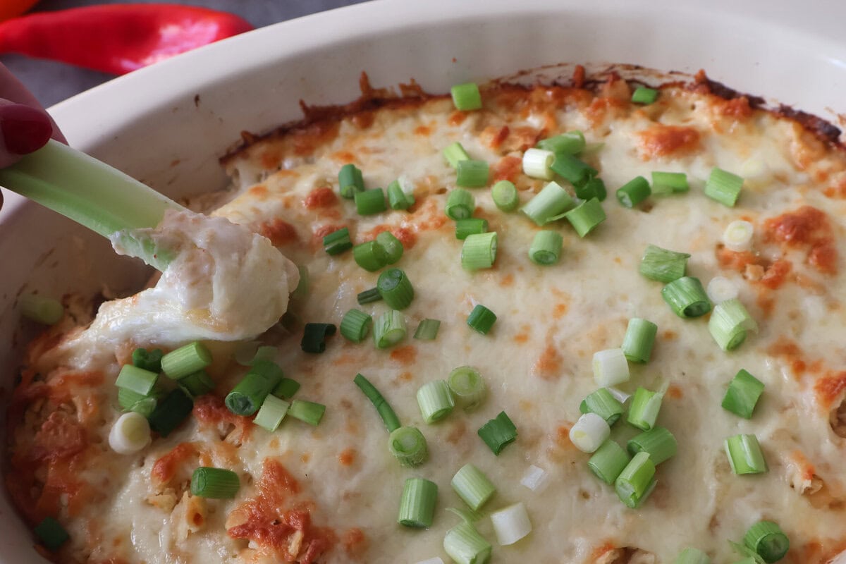 Jalapeno chicken popper dip with a celery stick.