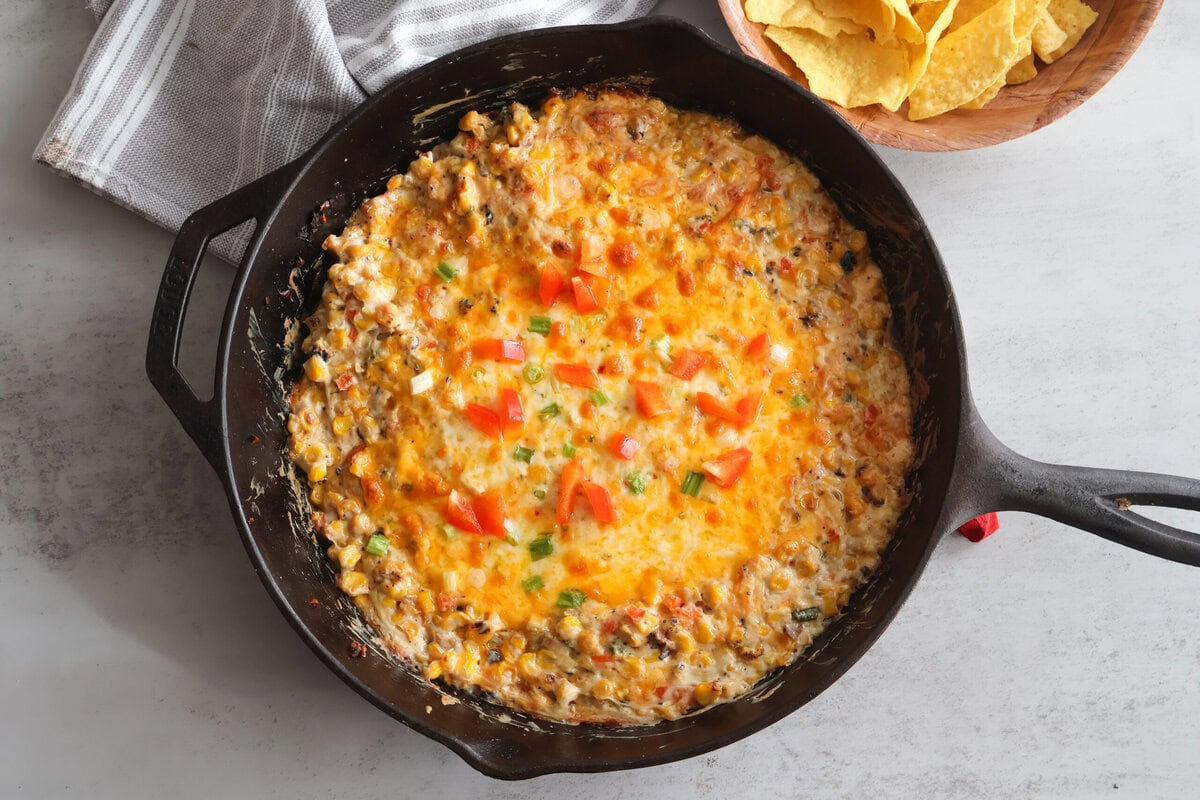 Baked Cheesy corn dip in a black cast iron skillet.