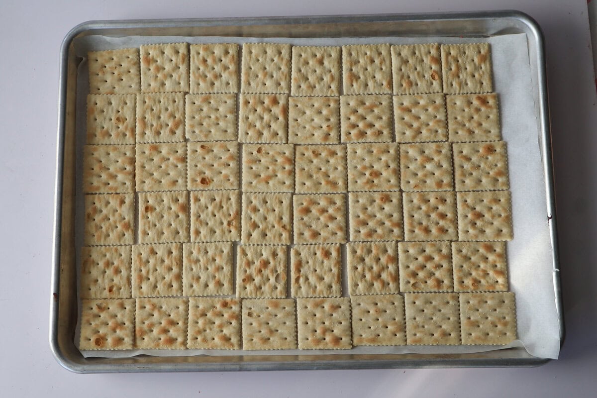 Layer of crackers on a sheet pan.
