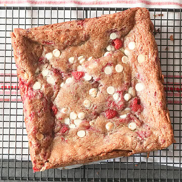 white chocolate raspberry blondies on a coling rack.