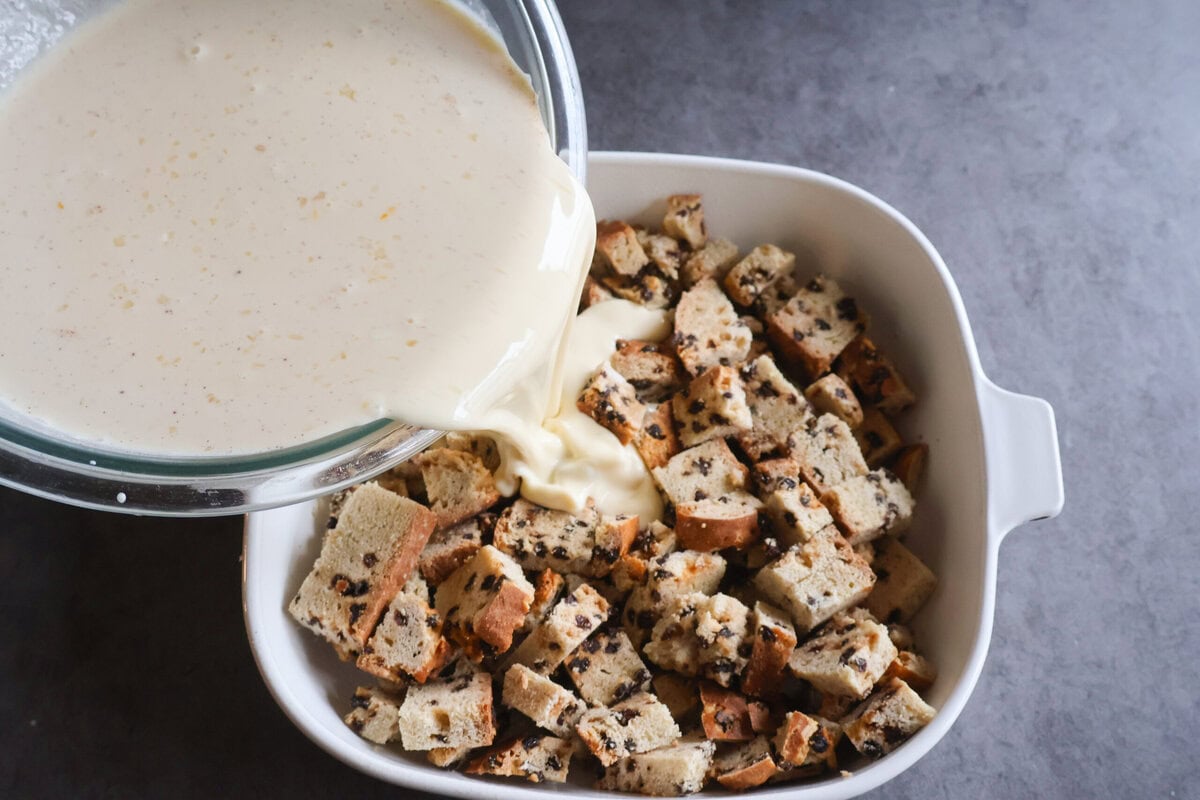 Custard mixture being poured over the Irish Soda Bread cubes.