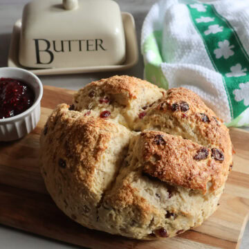 Irish soda bread with jam, a tea towel and a butter dish.