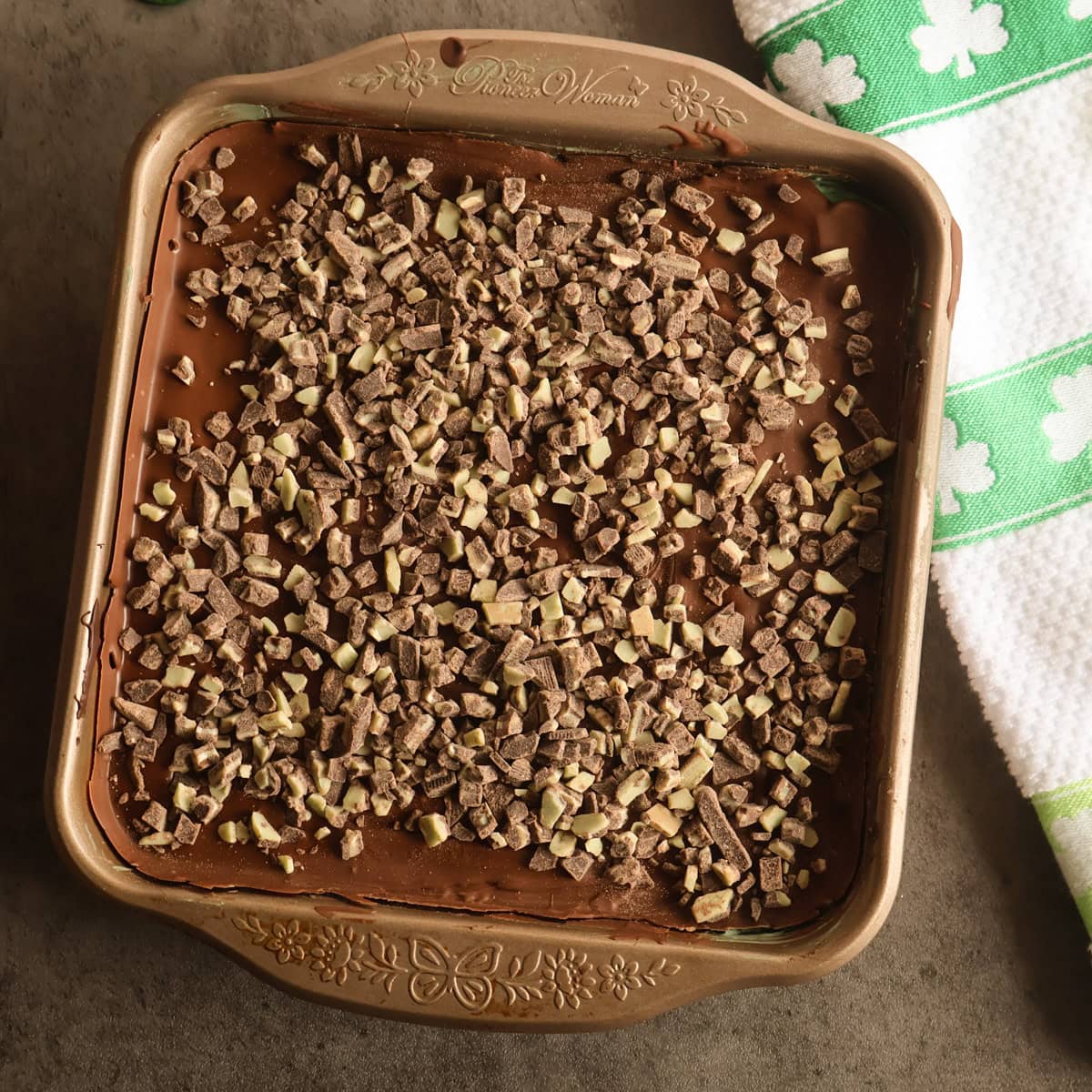 Grasshopper bars in a square pan with a shamrock napkin.
