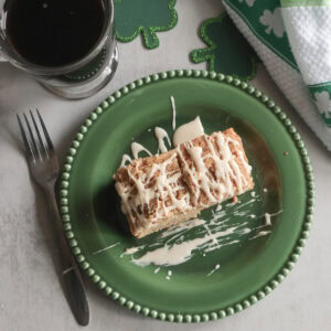 Irish Coffee Cake on a green plate with a cup of coffee