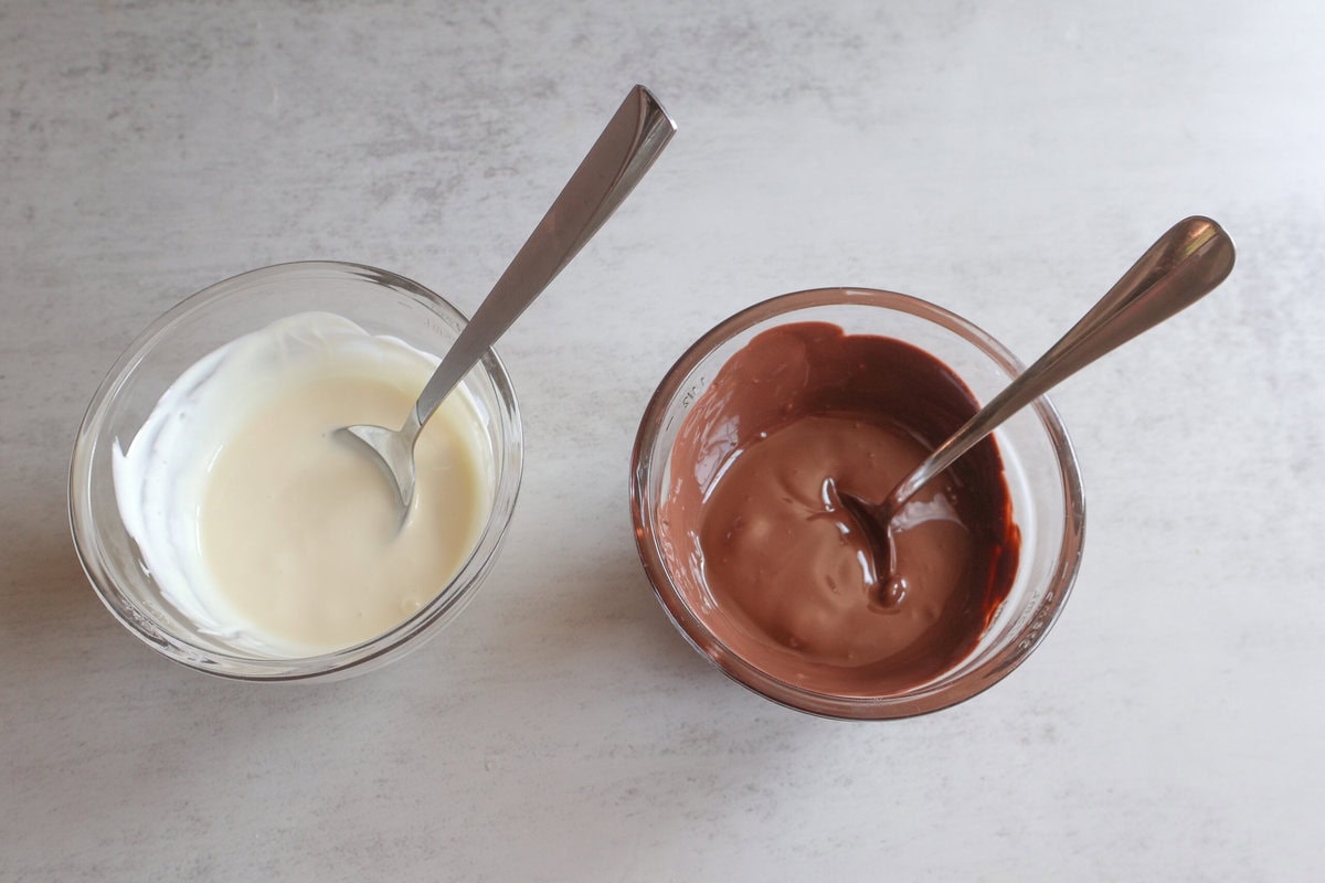 Melted chocolate in bowls with a spoon.