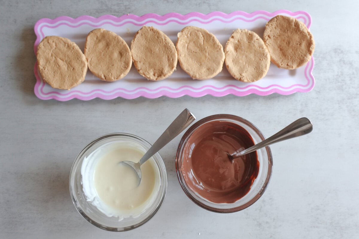 Peanut Butter Eggs with melted chocolate in bowls with a spoon.