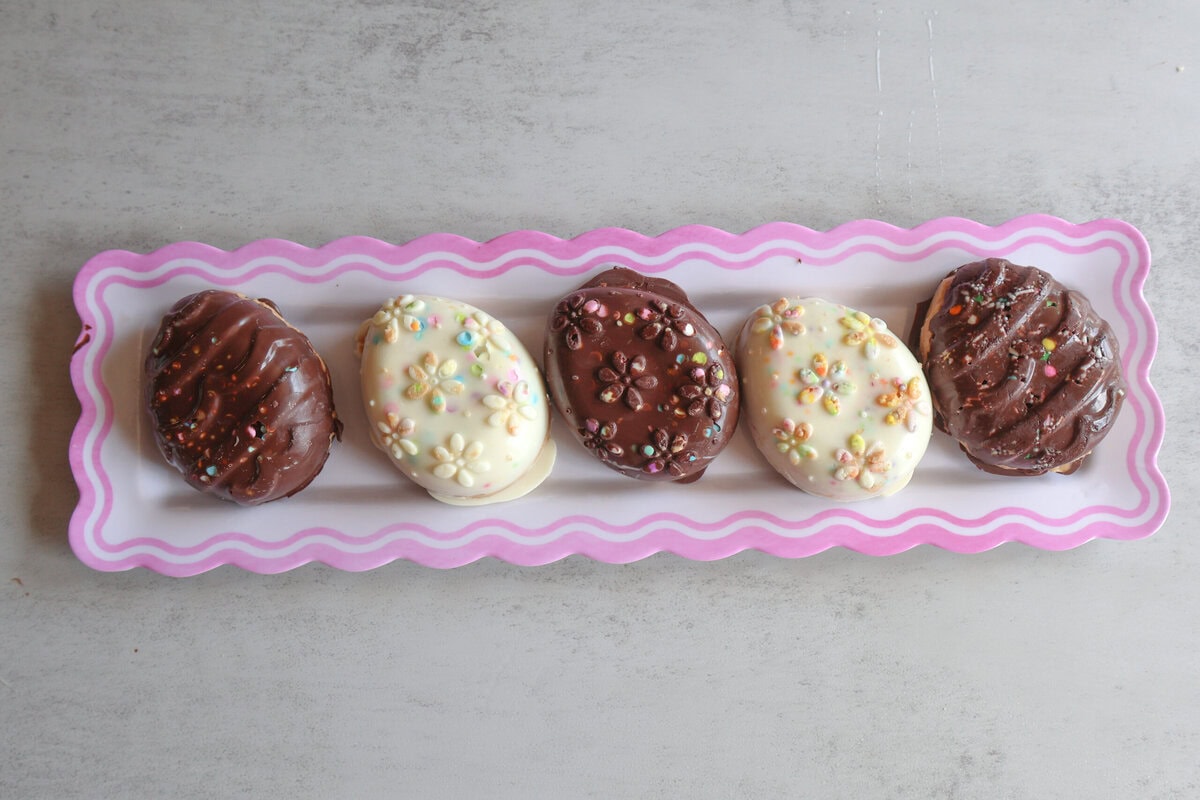 Chocolate and Peanut Butter Eggs on a pink and white plate.