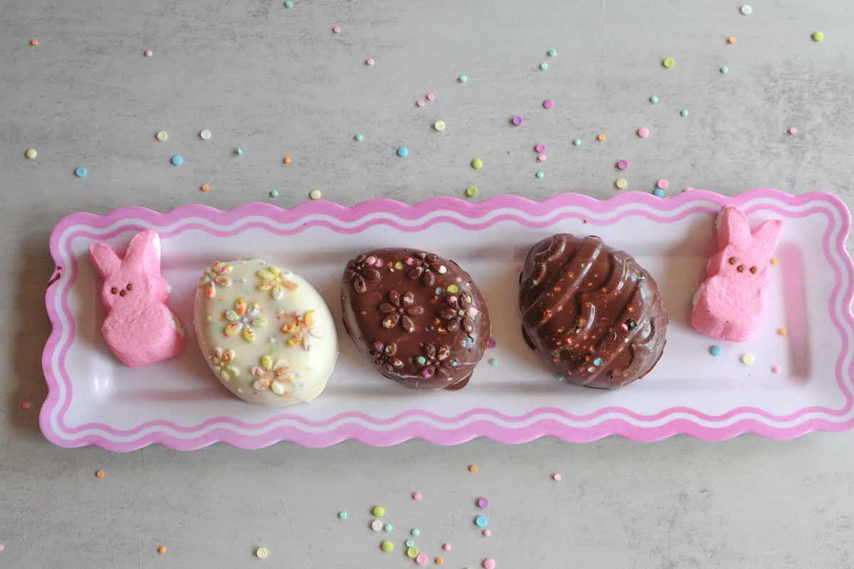 Peanut Butter Easter Eggs with bunny peeps on pink and white platter.