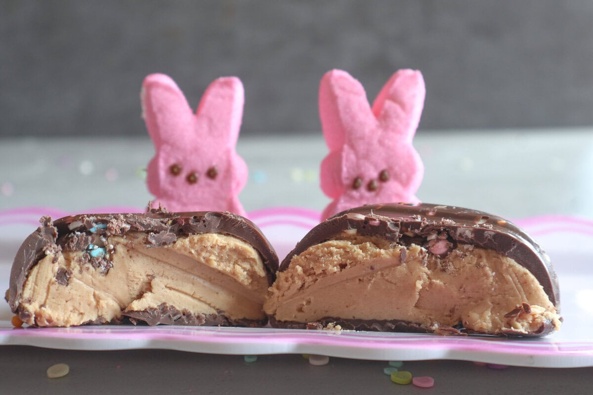 Peanut Butter Easter Egg cut in half with pink peep bunnies.