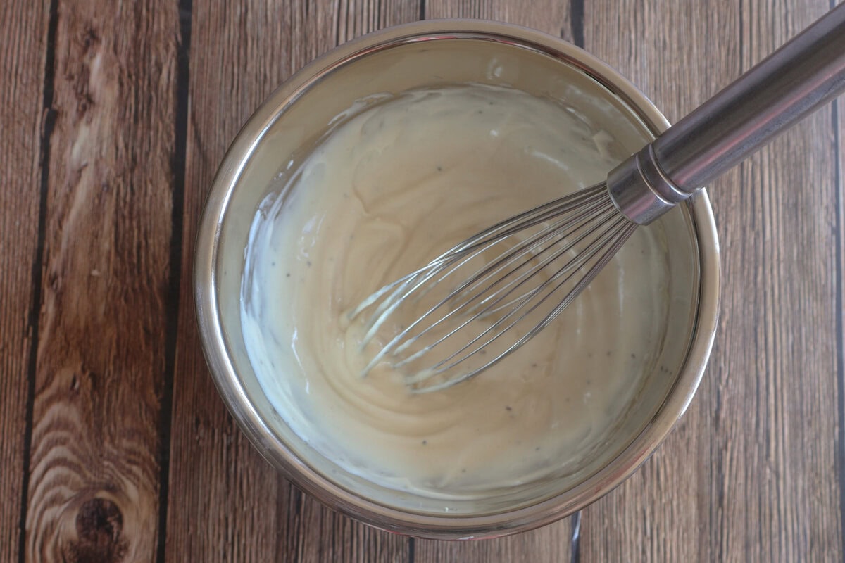Honey Dijon Dressing in a bowl with a whisk.