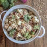 Creamy Cauliflower and Broccoli Salad with Honey Dijon Dressing in a white dish.