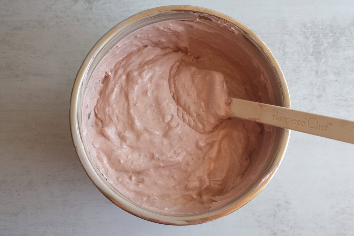 Pudding and cream mixture combined in a mixing bowl.