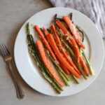Honey garlic carrots and asparagus on a white plate.