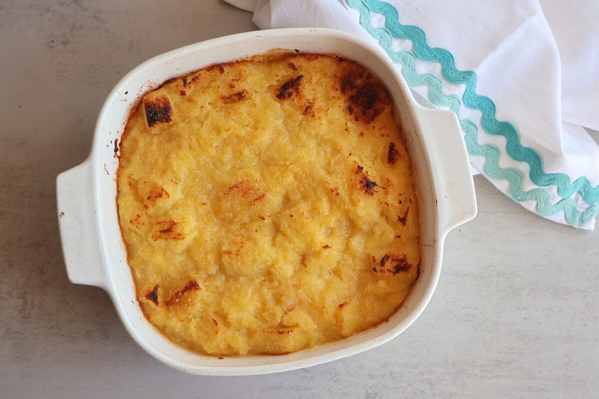 Baked pineapple in a white casserole dish.