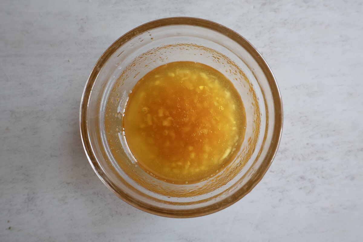 olive oil, honey, and garlic in a glass bowl.