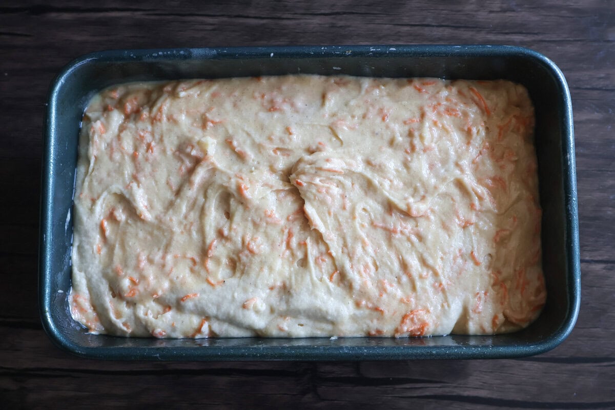 Carrot cake pound cake batter in a loaf pan.