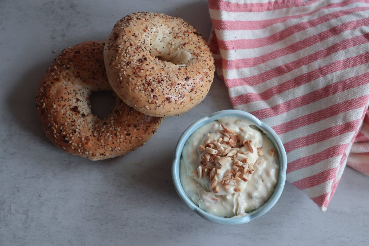 Honey almond cream cheese with bagels and white and pink striped tea towel.
