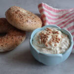 Honey almond cream cheese with bagels and pink and white striped tea towel.