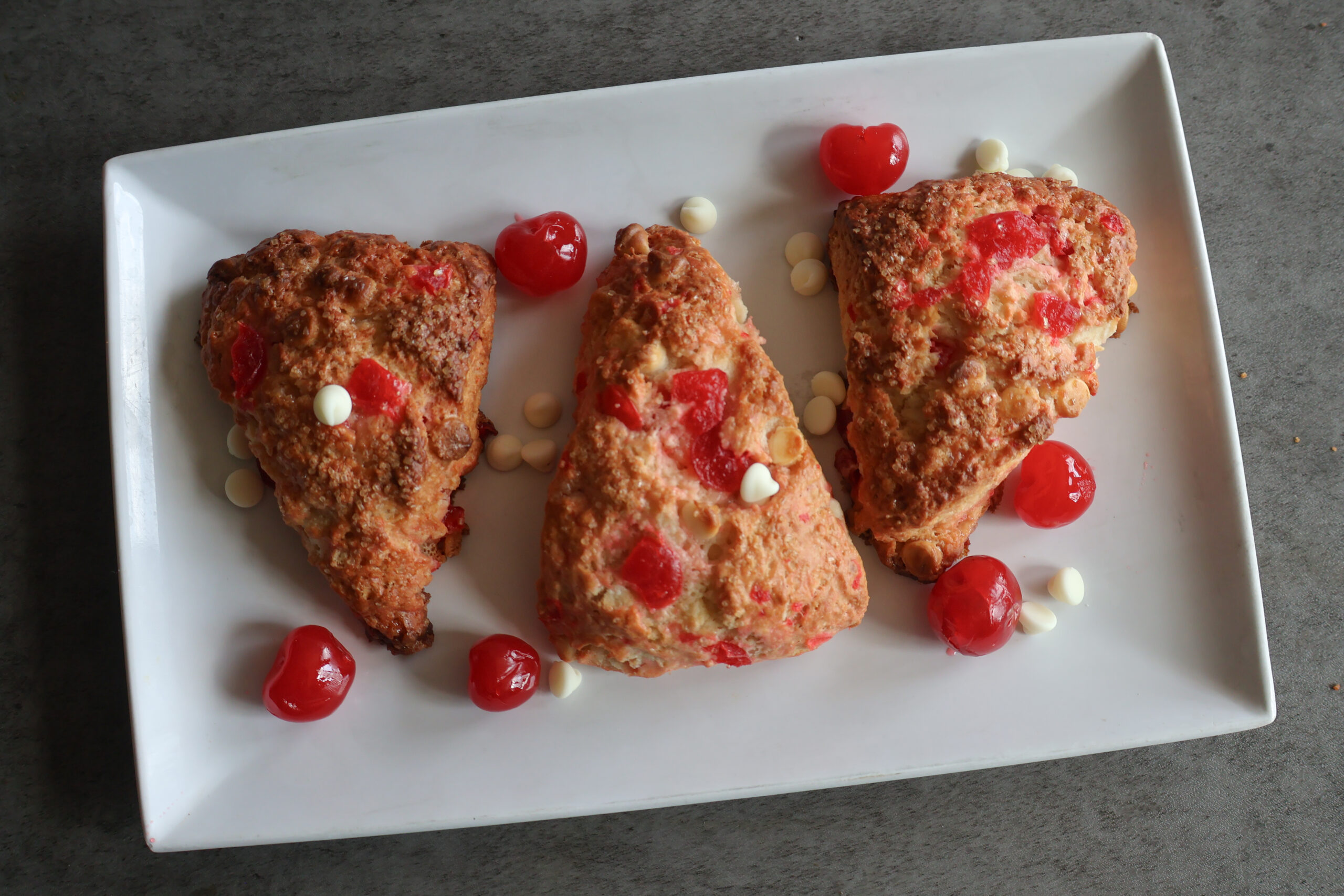 Cherry white chocolate scones on a white plate.