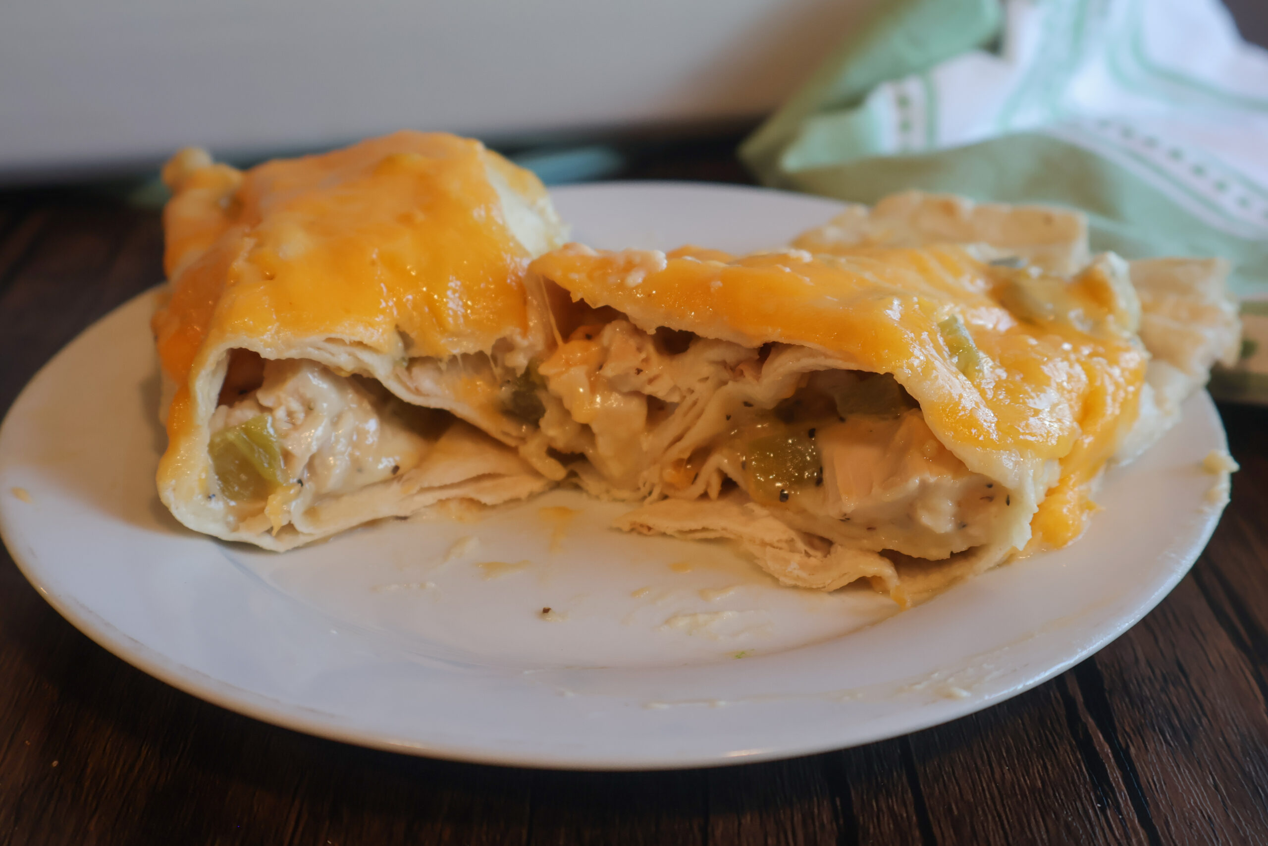 Creamy chicken enchilada sliced in half.