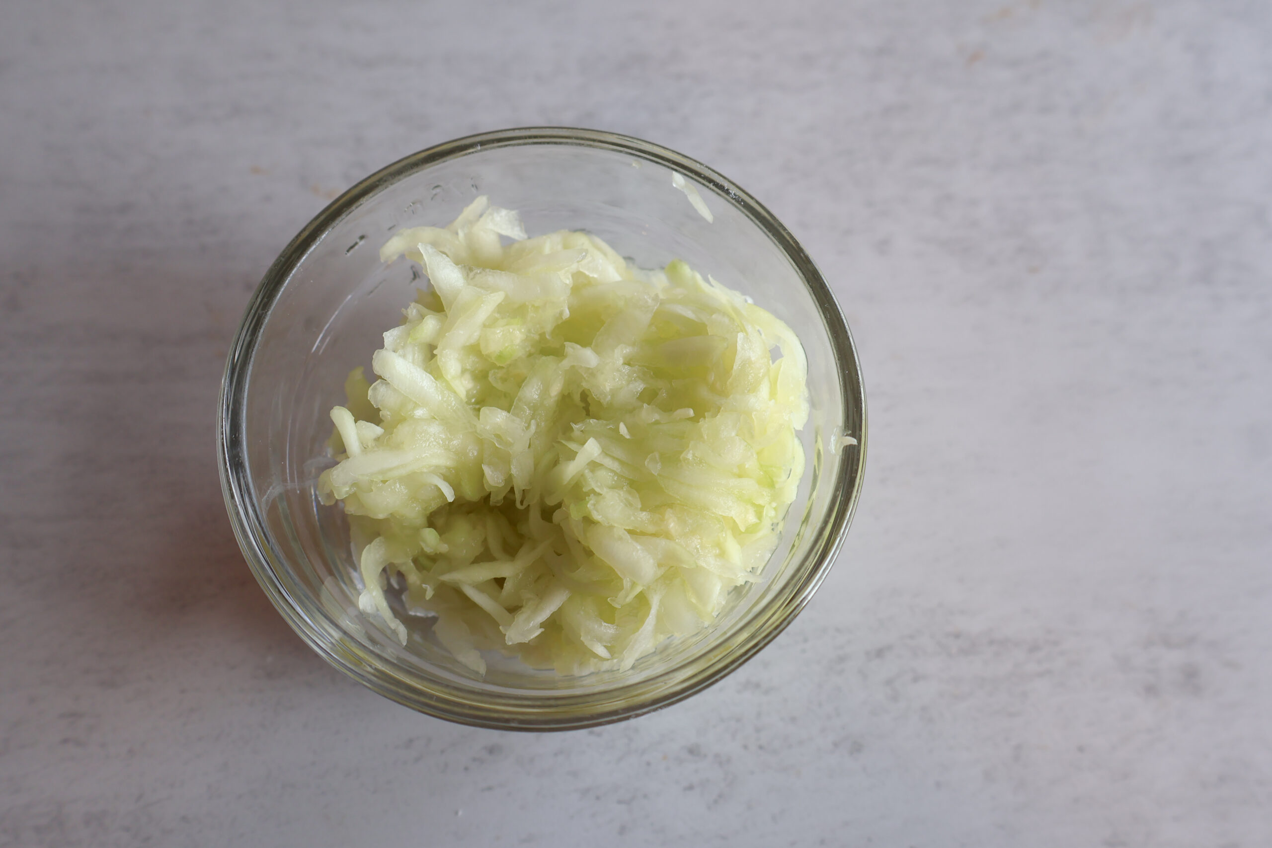 Small glass bowl of grated zucchini