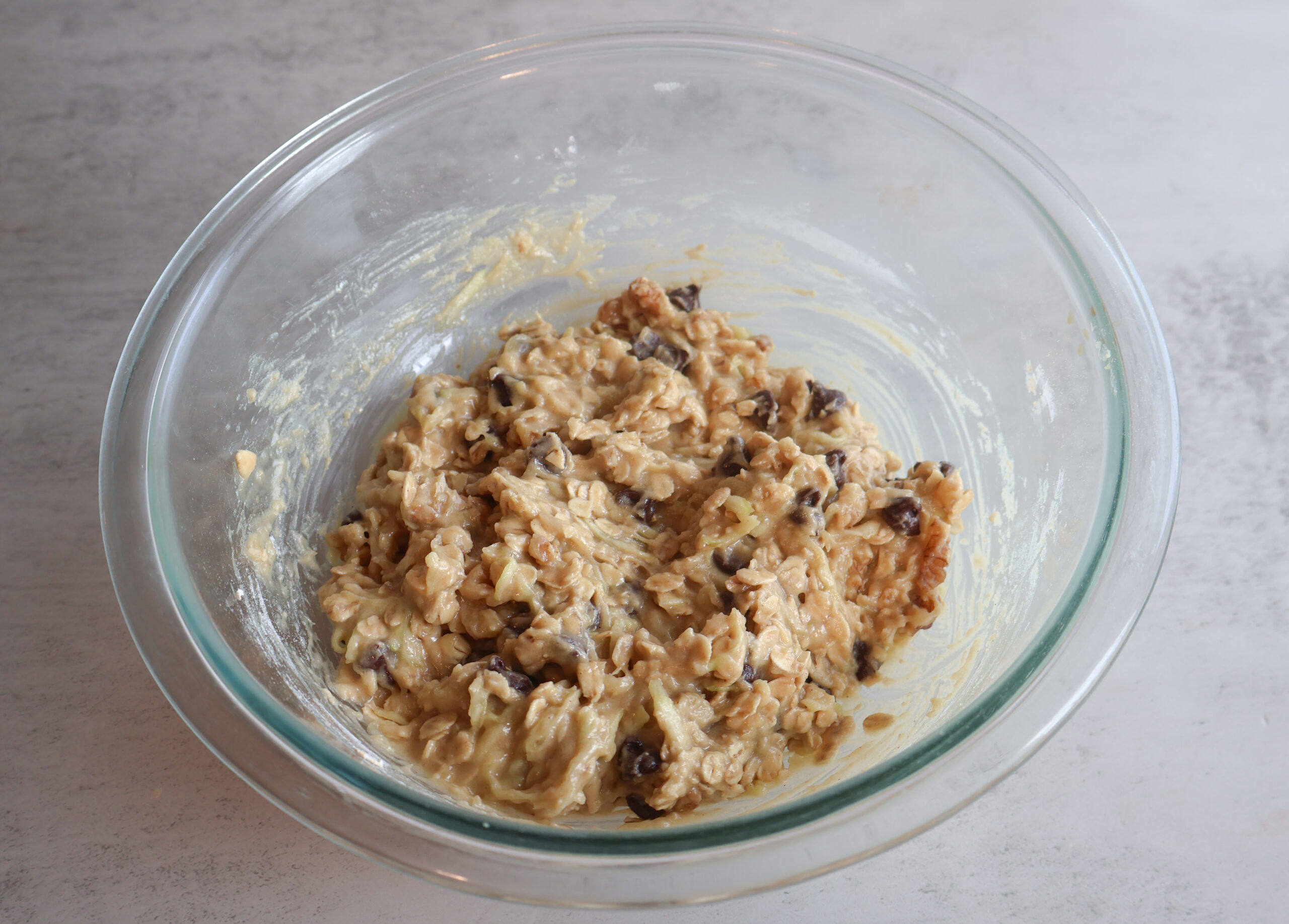 Dry ingredients added to wet ingredients in a glass bowl.