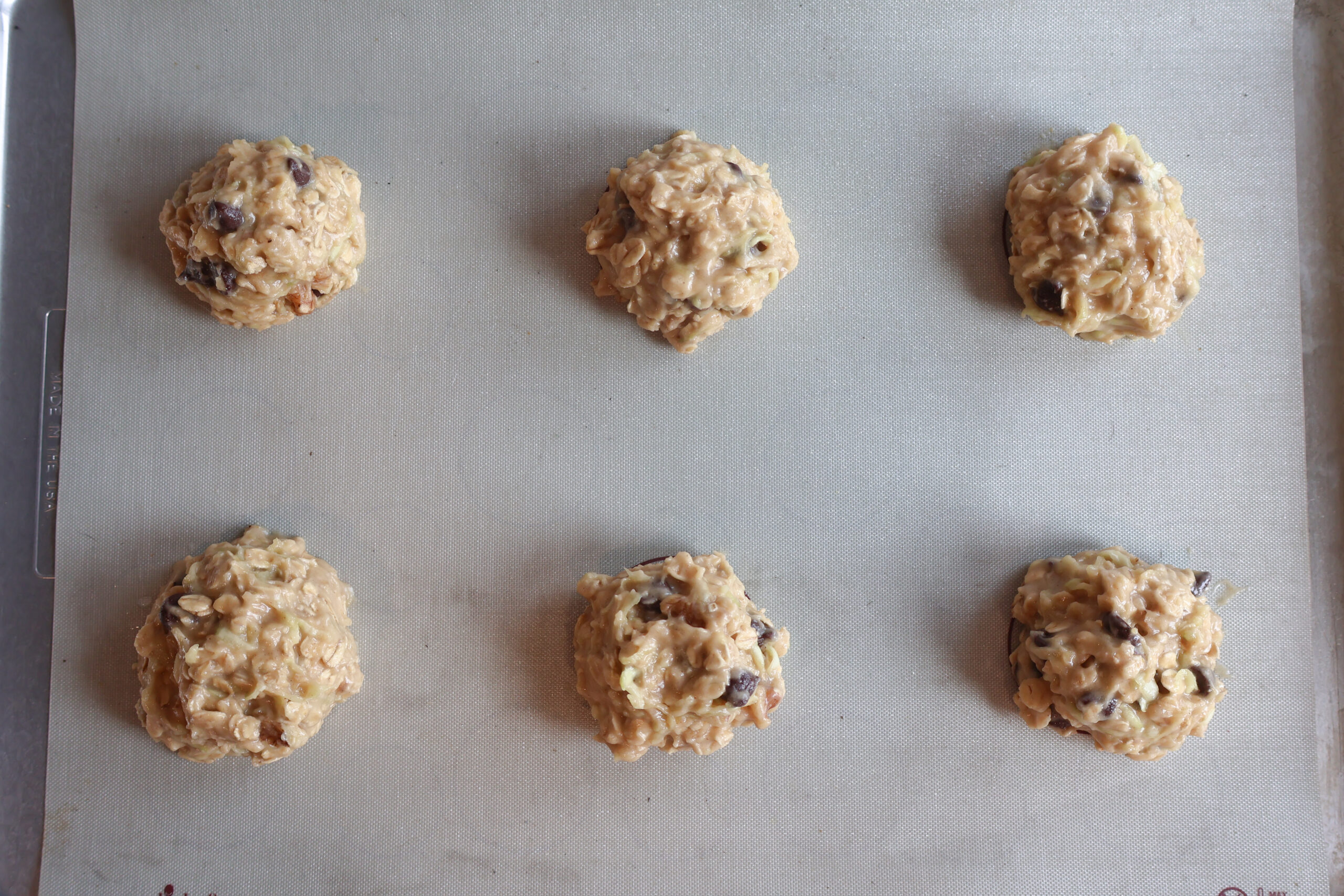 Zucchini breakfast cookies scooped on a baking sheet.