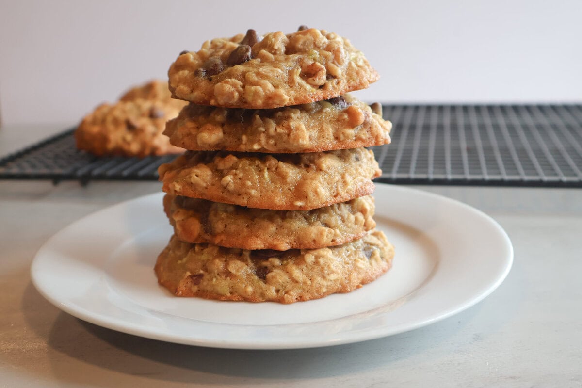 Zucchini breakfast cookies stacked on a white plate.