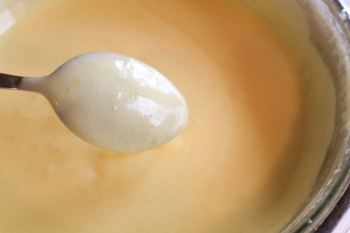 Lemon curd coating a spoon.