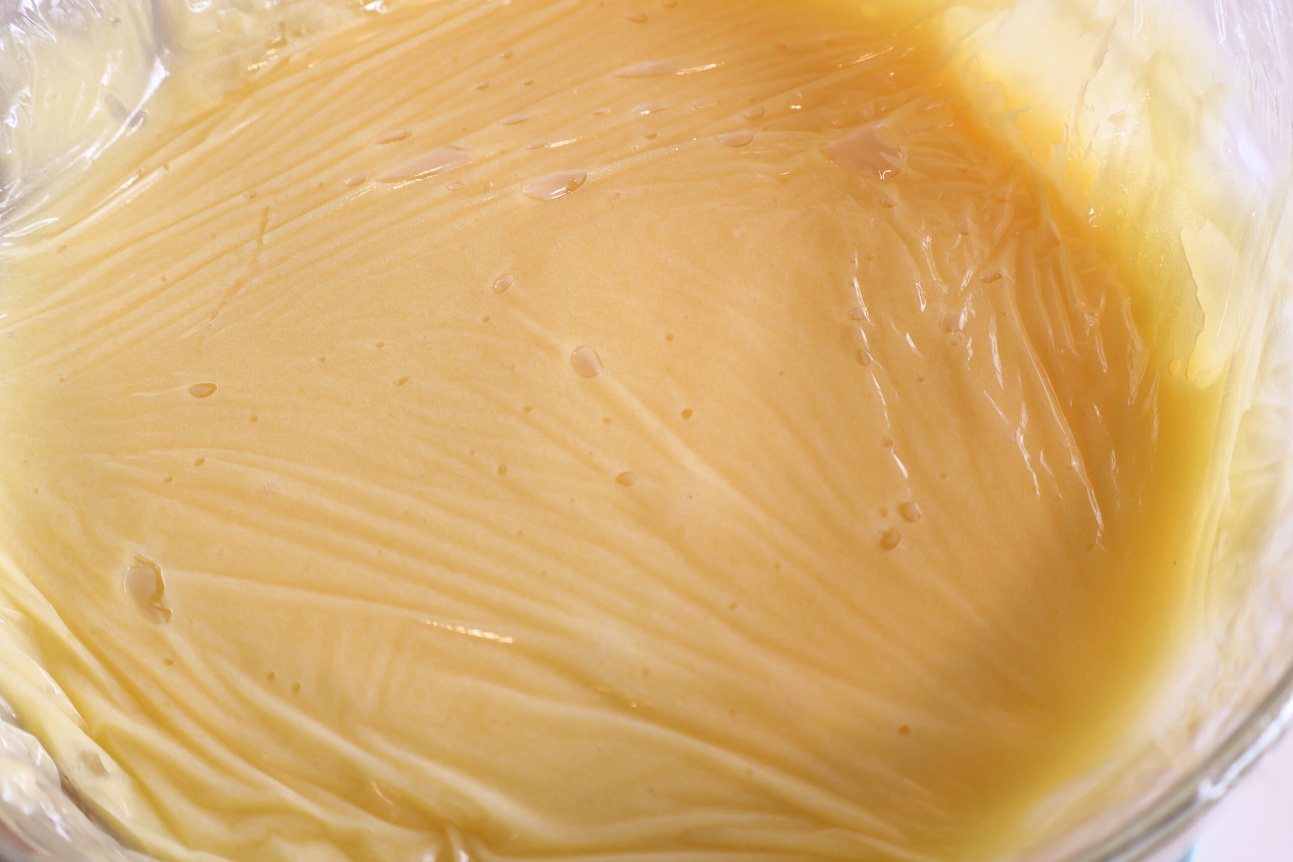 Lemon curd with plastic wrap.