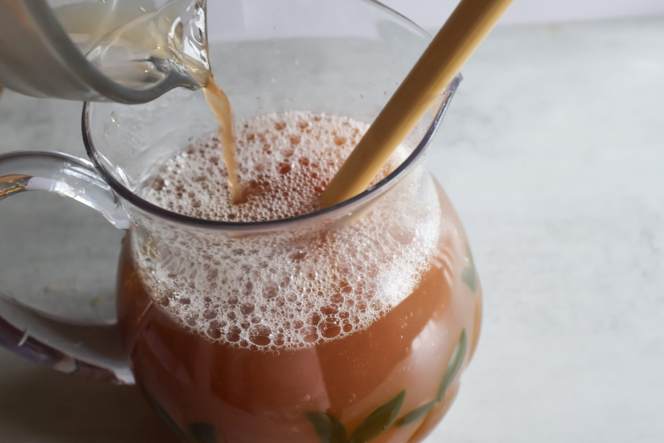 Iced tea and water being added to the summertime cooler.