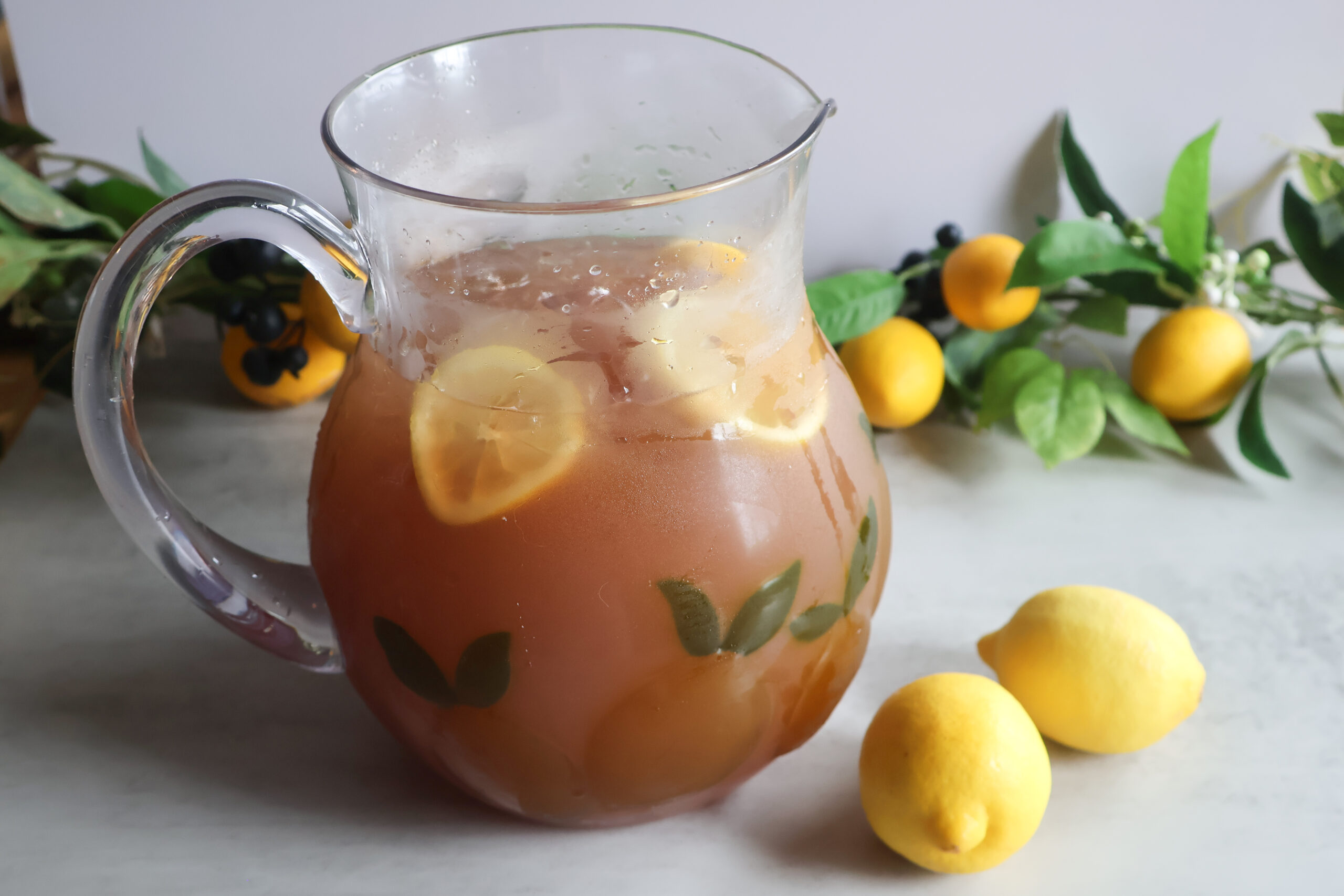 Summertime cooler in a glass pitcher with fresh lemon.