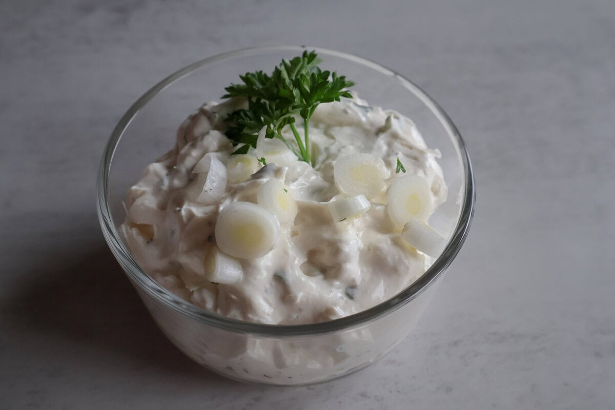 Creamy Green Onion Dip garnished with parsley in a small dish before serving.