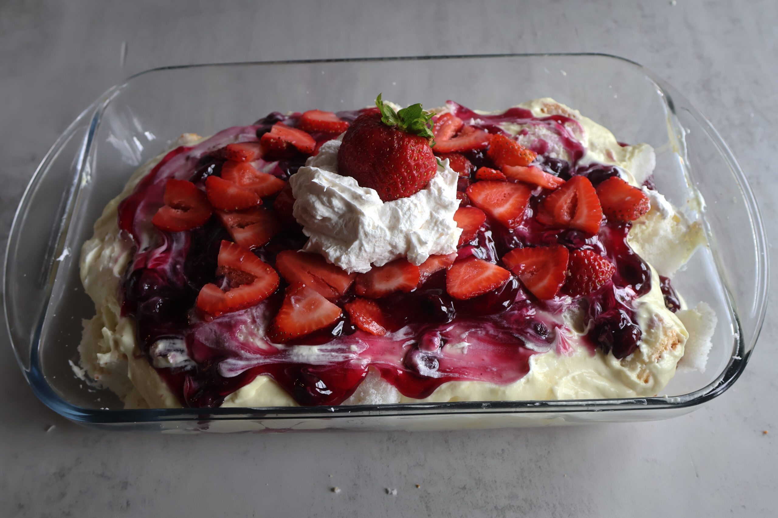 Lemon berry cloud dessert in a glass dish.