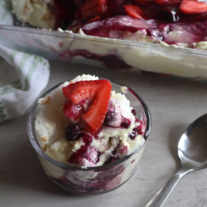 Lemon berry cloud dessert in a small dish with a spoon.