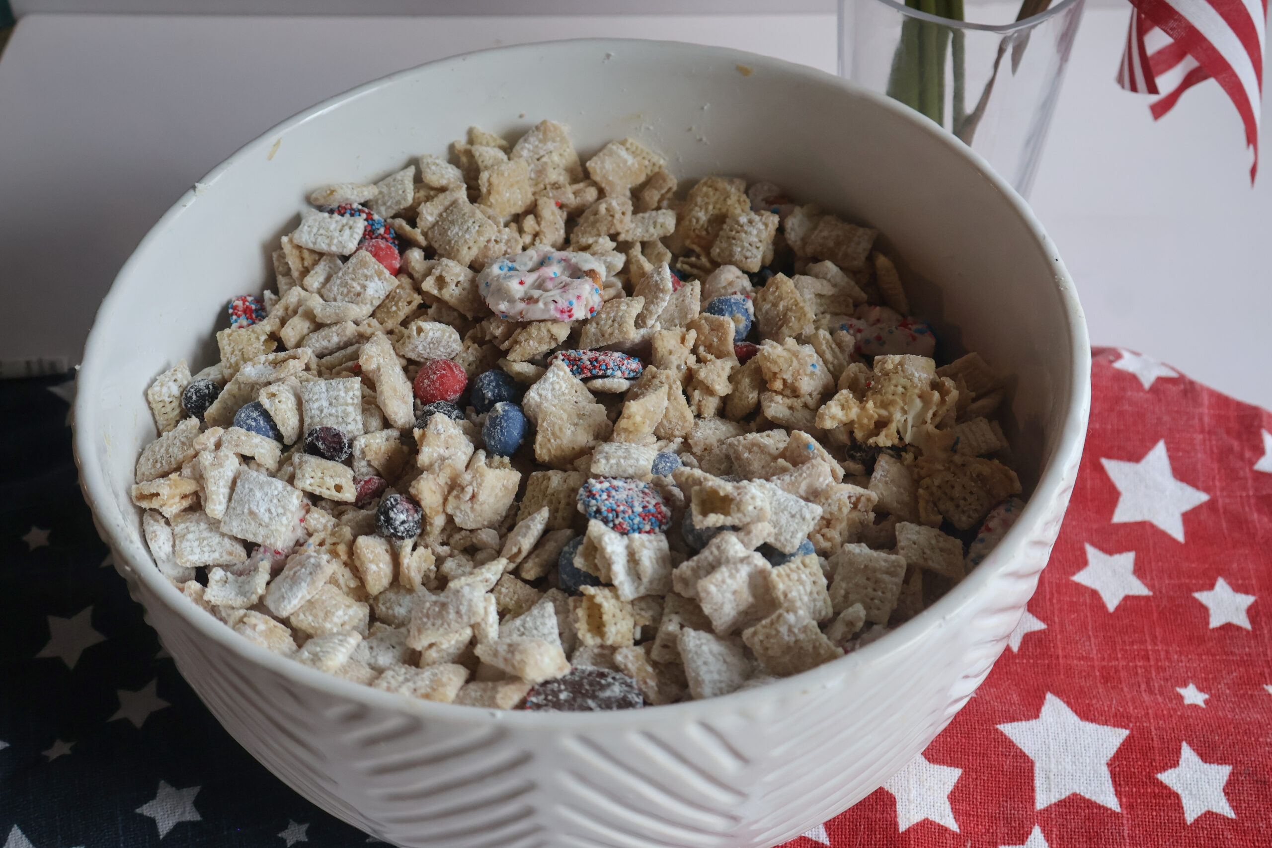 firecracker puppy chow in a white bowl with star placemats.