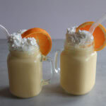 Creamsicle orange Frost in a mason jar glass with whipped cream and an orange slice.