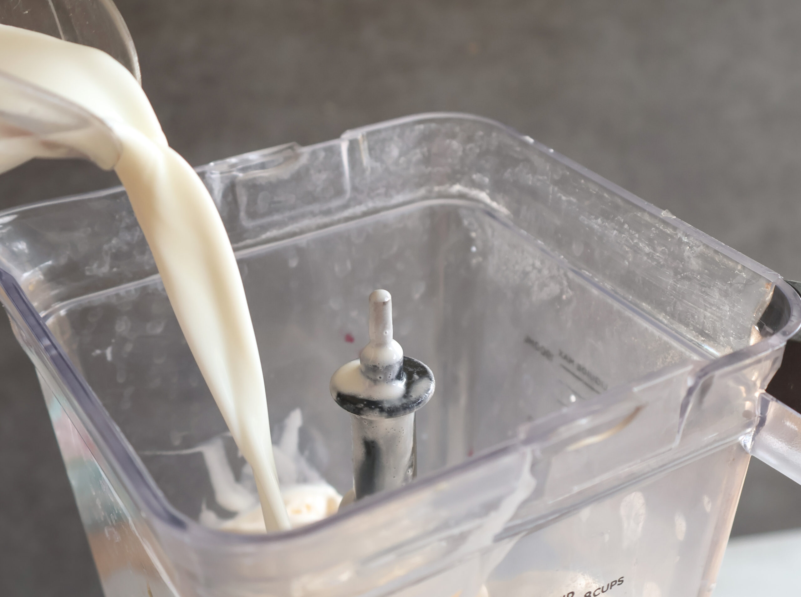 Milk being poured into a blender.