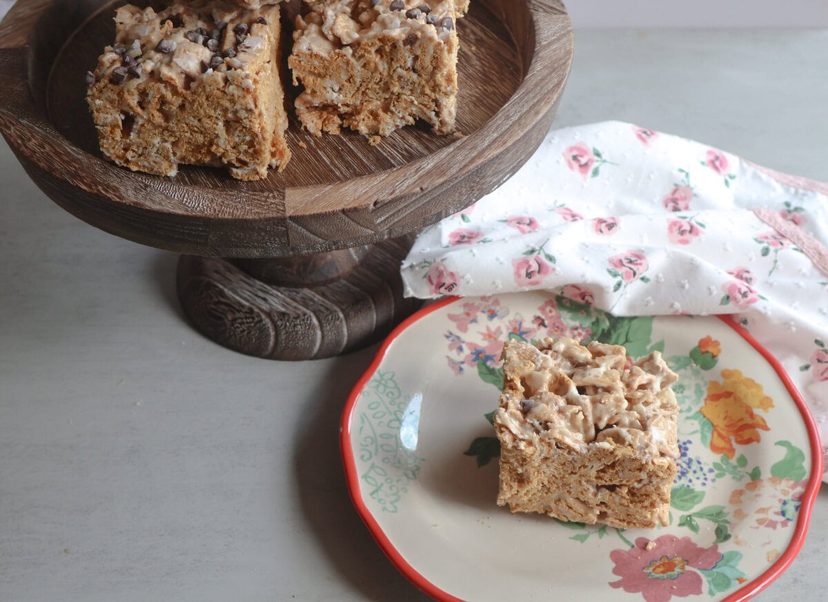 Salted honey golden grahams crunch bars on a wooden cake stand and a plate.
