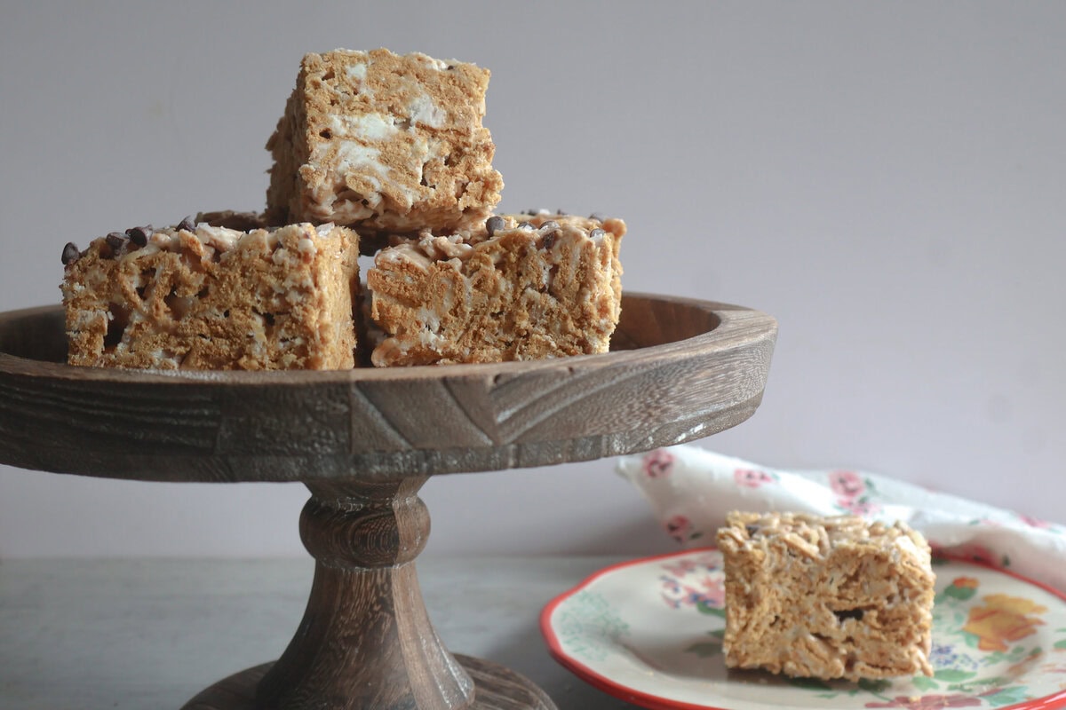 Salted honey golden grahams crunch bars on a wooden cake stand and on a plate.
