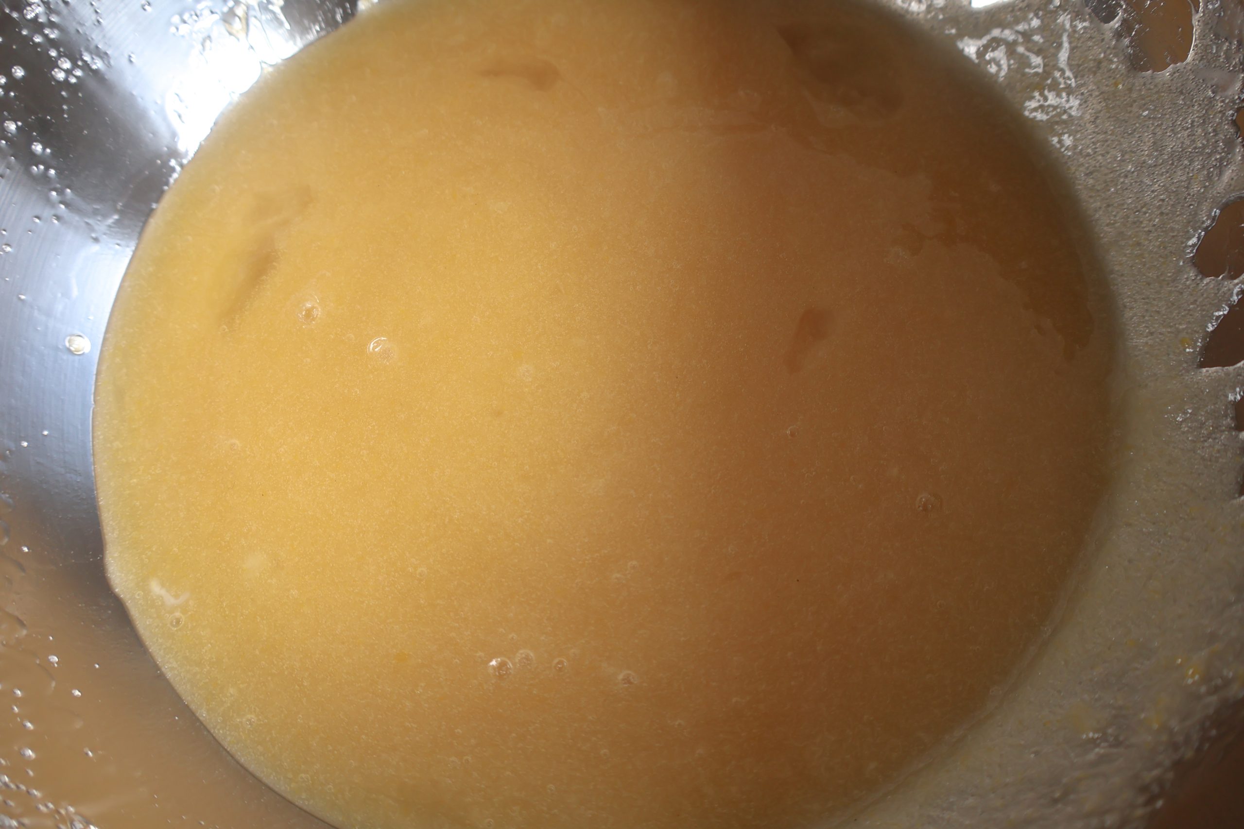 Eggs, sugar, oil, and vanilla whisked in a bowl.