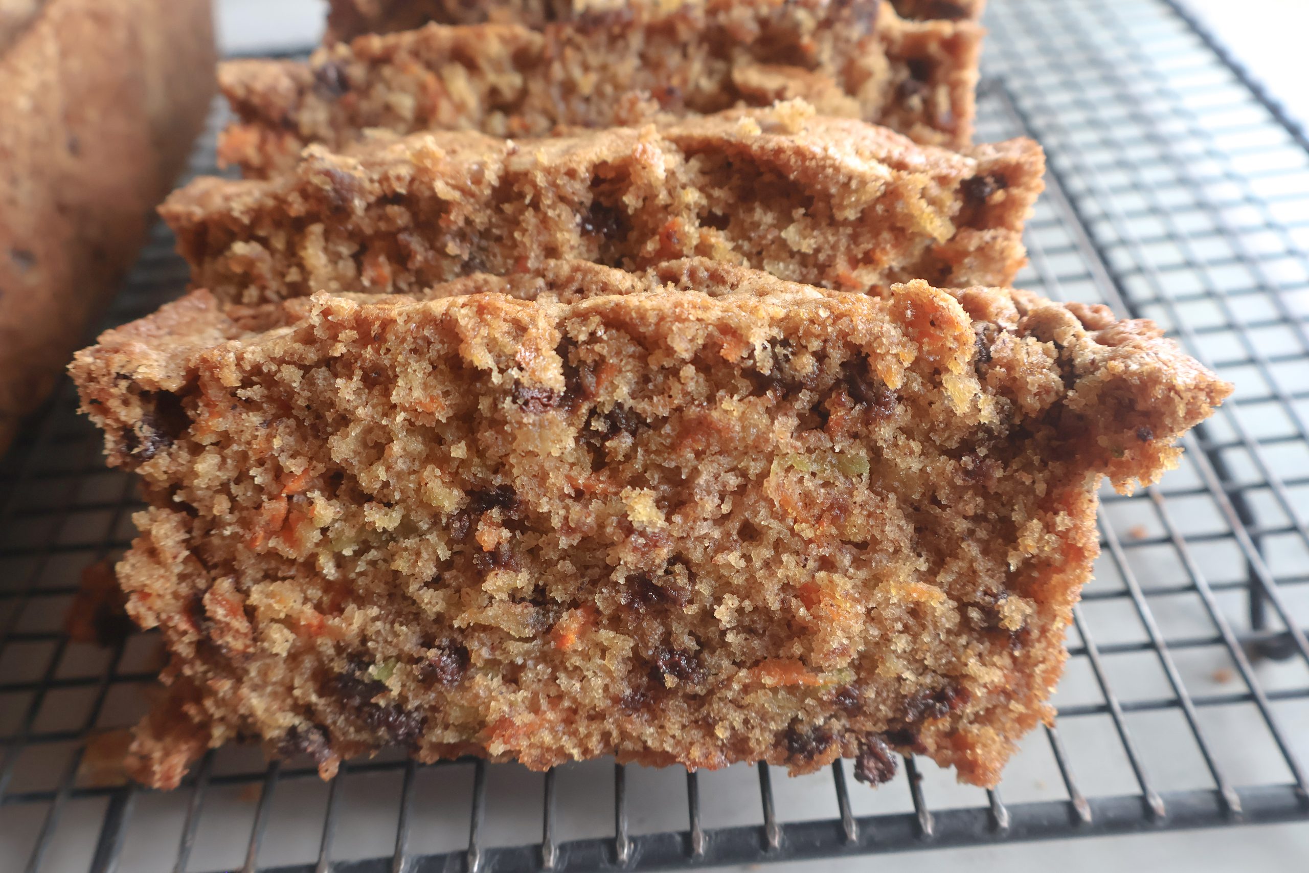 Sliced Chocolate chip zucchini carrot bread on a cooling rack.