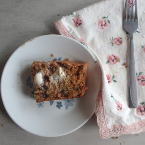 Chocolate Chip Zucchini Carrot Bread on a small plate with butter and a fork.