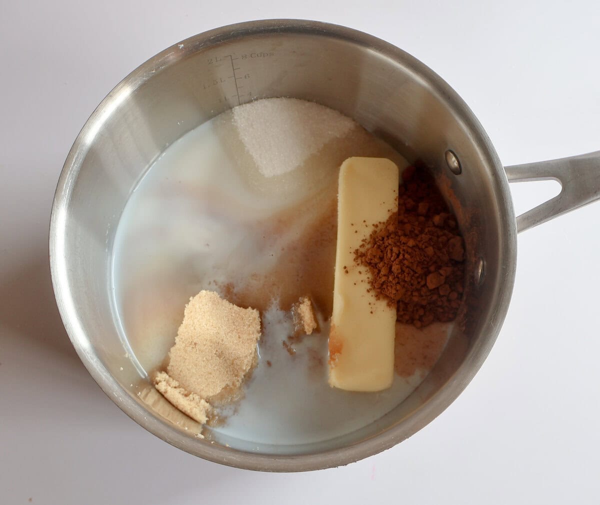 sugar, butter, cocoa, and milk in a pot.